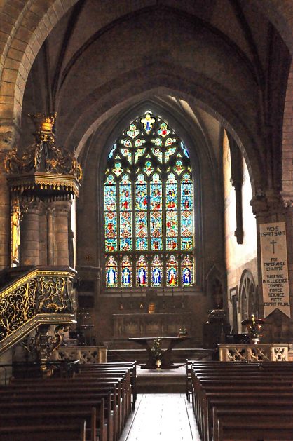 Vue d'ensemble du chœur baigné par les intenses coloris du vitrail des Rohan (1893).