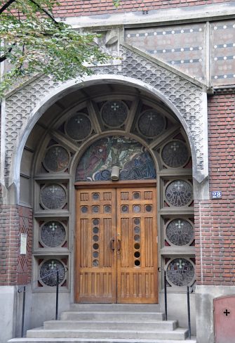 Une porte latérale de l'église entourée des vitraux de Jacques Gruber
