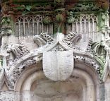 Écusson et sculpture florale dans le dais d'une niche