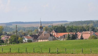 Paysage champêtre avec l'église Saint-Maurice en arrivant  depuis Gray