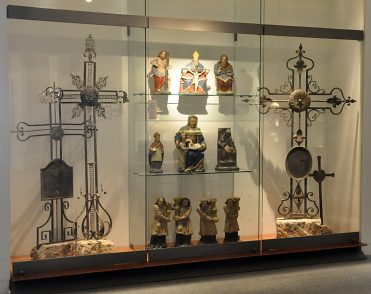 Vitrine avec croix et statues des Vosges.