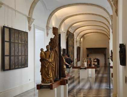 Couloir de l'ancienne abbaye avec statues et tableaux