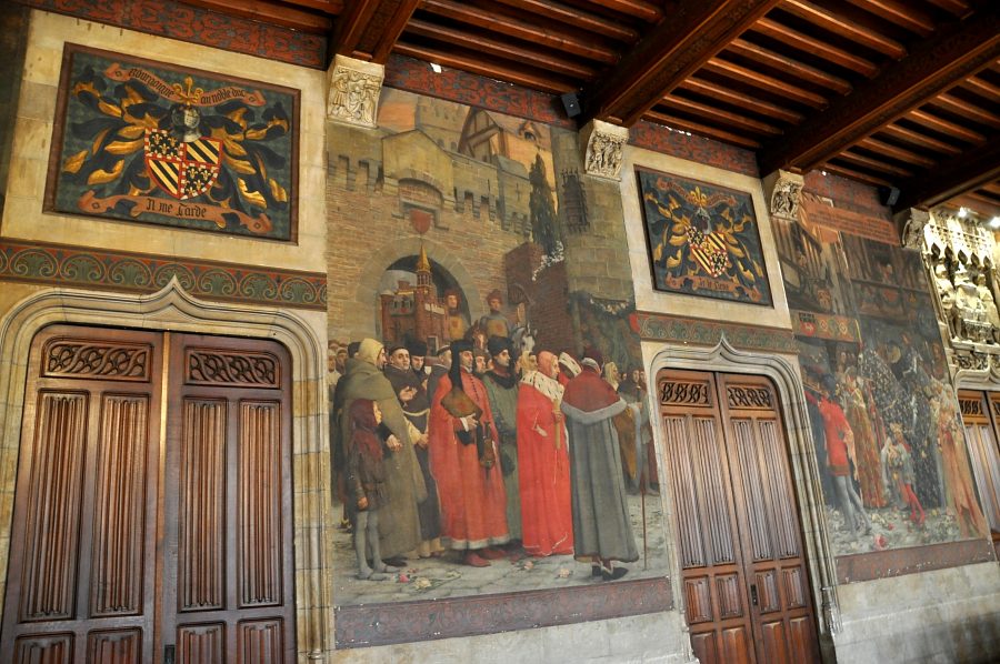 Salle du Conseil, le mur opposé aux fenêtres avec ses blasons et ses scènes historiées Salle du Conseil, le mur opposé aux fenêtres avec ses blasons et ses scènes historiées