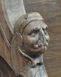 Tête sculptée sur un accotoir dans les stalles Tête sculptée sur un accotoir dans les stalles
