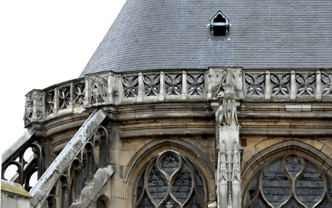 Au chevet, les arcs–boutants sont surmontés d'un garde–corps orné de masques