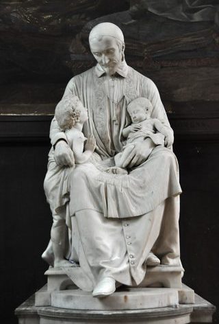 Saint Vincent de Paul assis tenant des petits enfants
