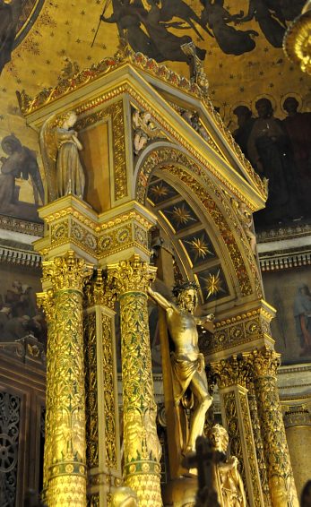 Le baldaquin en bois doré et ses colonnes couvertes de feuilles de vigne et d'anges