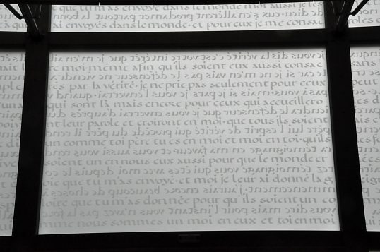 Les inscriptions sur la verrière de la façade sont portées en mode «boustrophédon». On peut y lire une ligne sur deux. Celles qui ne