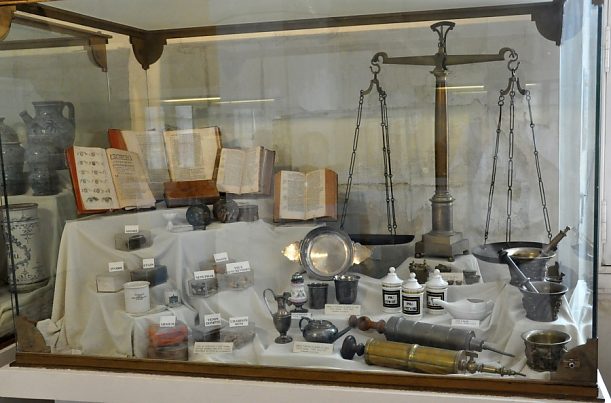 Vitrine avec balance, mortiers et livres